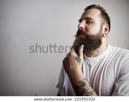 Portrait of a tattooed bearded man wearing white t-shirt