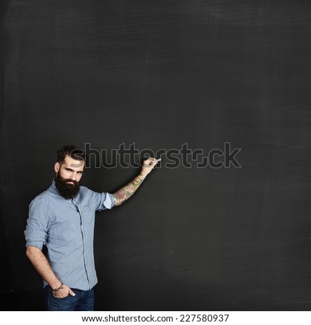 Bearded man draws on a chalkboard