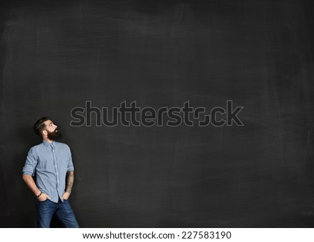 Bearded man looks at chalkboard