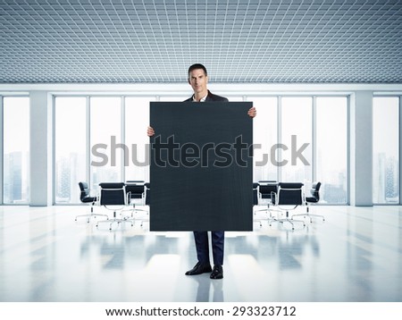 Businessman with blackboard at contemporary office