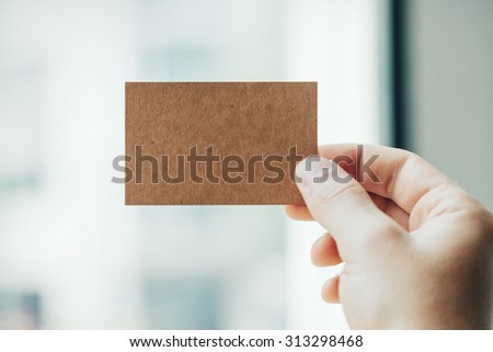 Hand holding business card on blurred background