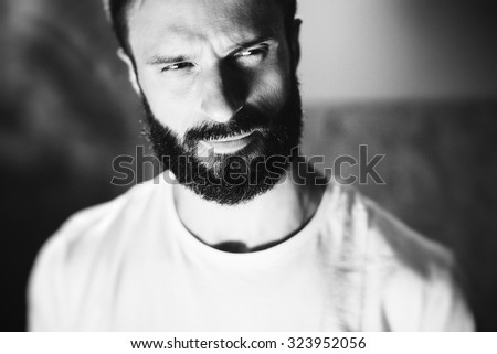 BW portrait of a bearded man wearing white tshirt on the blure background