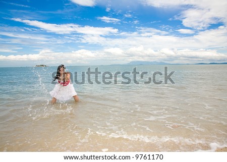 woman splashing sea water by the seashore