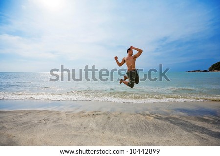 happy man jumping excitedly by the beach