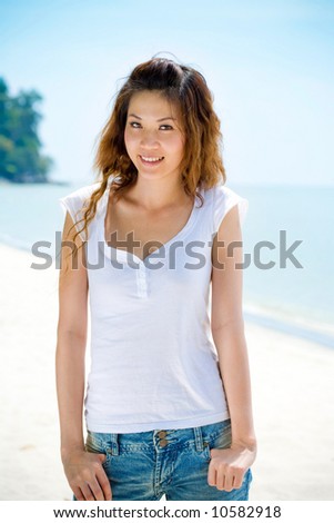 young asian woman in casual wear jeans smiling at the beach