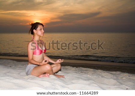 relaxing woman closing her eyes doing meditation on the sunset beach