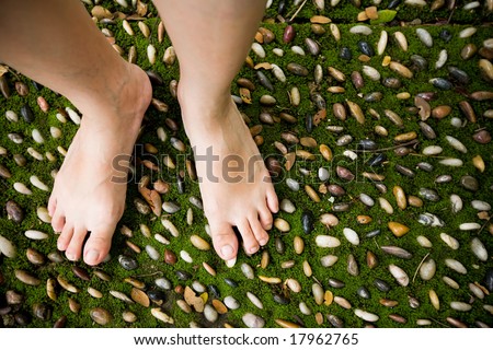 female bare feet stepping on therapy stones