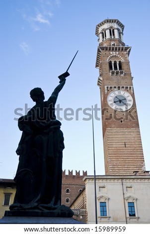 Detail shot of statue of justice with palazzo della ragione in the background.