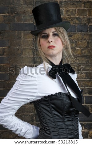 Portrait of beautiful woman in late victorian costume against brick wall