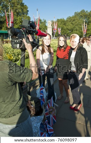 LONDON - APRIL 27: Fans outside Buckingham palace with royal family masks to celebrate the royal wedding celebration to take place April 29. April 27, 2011 in London, England.