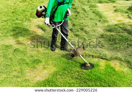 Worker cutting grass using electric lawn mowers.