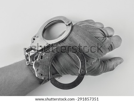 Hand in a boxing bandage with handcuffs top