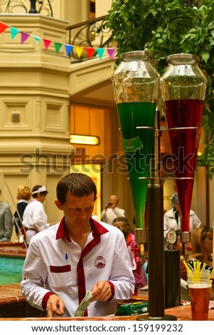 MOSCOW, RUSSIA. JUNE 2. A man serves colorful fruit juices and ice creams in GUM shopping center located in Red Square, Moscow, Russia. Taken on June 2nd 2013.