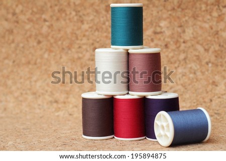 Spools of thread  multicolored on cork board