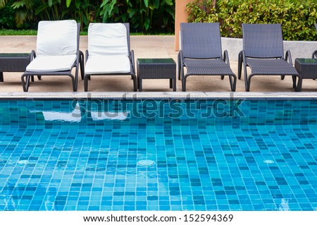 Swimming pool with black and white beach chairs
