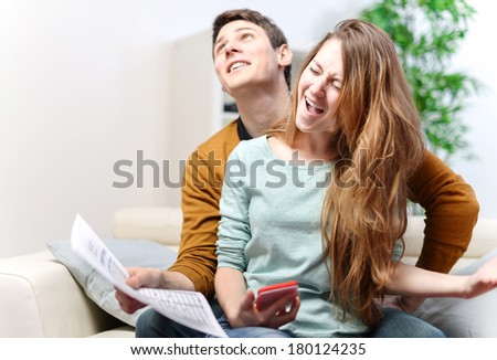 happy young couple consulting their bank account with joy