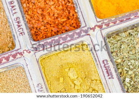 Colorful wooden box with various spices, powder and herbs