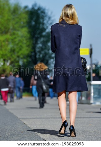 Back view of Young business leader woman walking on the city street