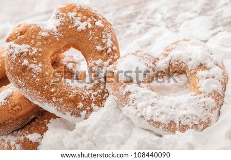 Two heart shaped cookies covered with powdered sugar
