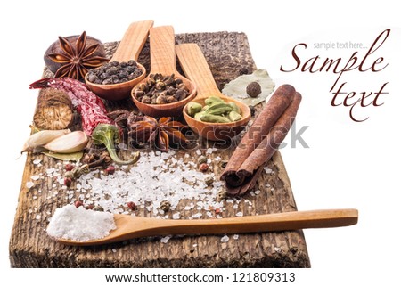 Spices on wooden table with spoons on white background