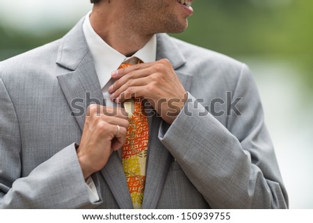 Man fixing his tie during wedding