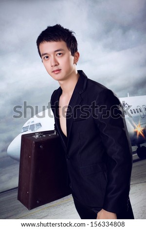 Young man with suit case ready for business trip at airport