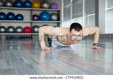Muscle man  push ups in fitness center