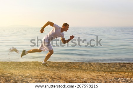 Man start running on the beach with the with the blue sky in the background and open space around him