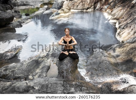 meditation.photo of the girl who is sitting in the lotus position on the rocks at the water