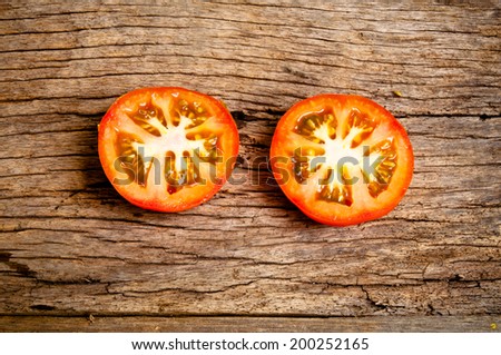 Half Cut Sliced of Fresh Tomato on Wood Table Background, Rustic Still Life Style.