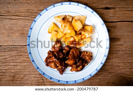 Barbecued Pork Spare Ribs Chopped and French Fries Potato Wedges on Wood Table Background, Rustic Still Life Style / Homemade Menu.