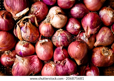 Fresh Red Onion Unpeeled with Woven Basket kitchenware harvest from farm garden on Wood Table Background, Rustic Still Life Style.