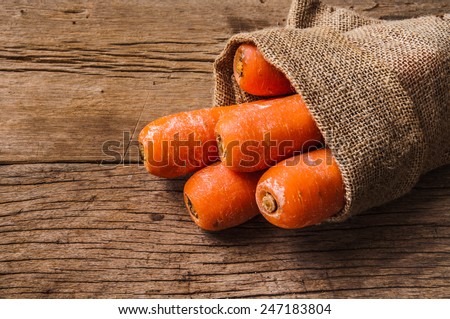 Pack of Fresh Harvest Carrot with Vintage Burlap Bag on Wood Table Background, Concept and Idea of Food Cook Rustic Still life Style.
