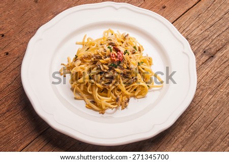 Spaghetti Vongole Fresh Clams with Chilli and Garlic, in vintage white plate, on wood table background, rustic still life style.