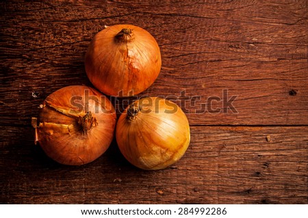 Fresh Group of Three Organic Onions Harvest on Vintage Wood Table Background, Rustic Still Life Style.