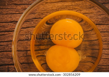 Fresh Eggs, Twin Egg Yolk in Glasses Bowl on Wooden Table Background, Country Rustic Style. Concept Idea of Cooking and Baking. Top View Close up.