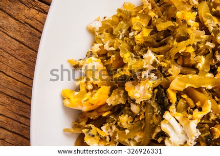 Stir Fried Pickled Mustard Green Cabbage with Eggs. Traditional Ingredients, Asian Cuisine. Homemade Style. Wood Background. Close up.