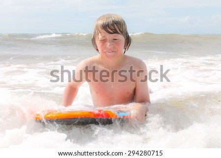 Young boy body boarding in white water
