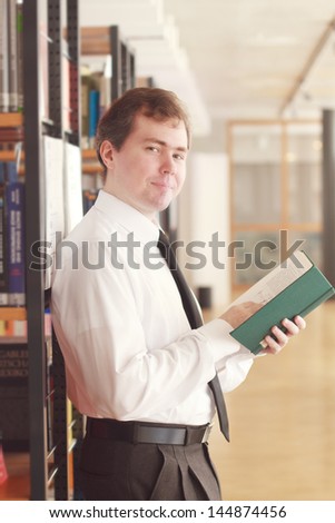 Young man with a book at the library
