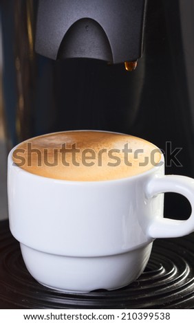 Cup of coffee on coffee machine