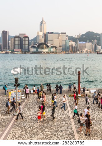 Hong Kong, Hong Kong - April 26 2015: Tourists take pictures and enjoy the famous Hong Kong island skyline across Victoria Harbour from the avenue of stars in Kowloon.