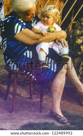 Vintage photo of grandmother with baby granddaughter (1982)
