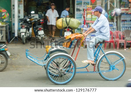 HO CHI MINH CITY, VIETNAM - JANUARY 5: An unidentified cycle rickshaw driver rides on January 5, 2013 in Ho Chi Minh City, Vietnam. Trishaws are used to ferry tourists around the city for sightseeing.