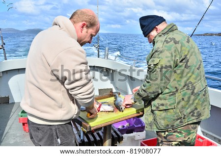 Deep sea fishing - gutting fish on boat