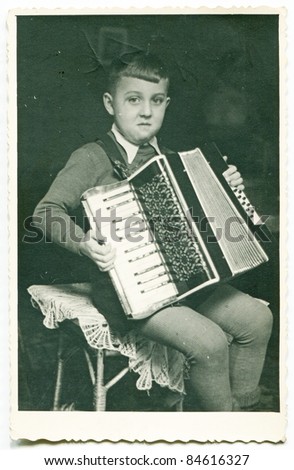 Vintage photo of boy playing an accordion (fifties)