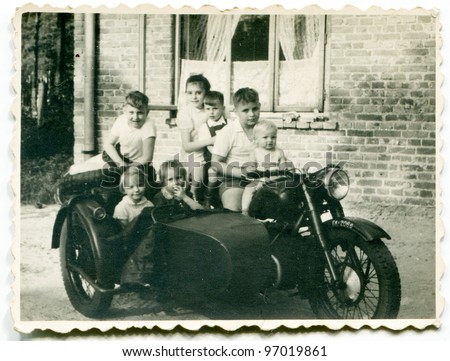 Vintage photo of group of children on motorcycle with a trailer (fifties)
