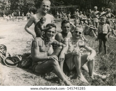 RAWICZ, POLAND, CIRCA THIRTIES - vintage photo of group of men with a monkey on beach, Rawicz, Poland, circa thirties