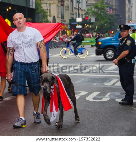 NEW YORK - SEPTEMBER 6: An unidentified man with a dog wearing Polish flag participates in the 76th Annual Pulaski Day Parade held on September 6, 2013 in New York.
