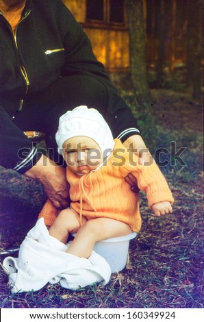 Vintage photo (scanned reversal film) - grandmother with baby granddaughter on potty, early eighties