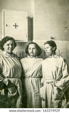 LODZ, POLAND, CIRCA 1950 - Vintage photo of group of medical university students wearing aprons during practical training, in Lodz, Poland, circa 1950